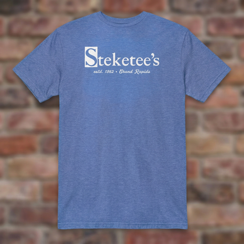 Steketee's Heather Royal T-shirt flat lay on brick background