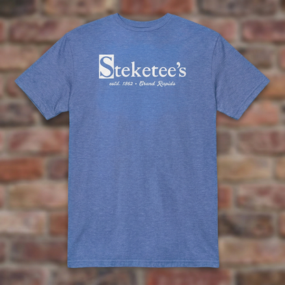 Steketee's Heather Royal T-shirt flat lay on brick background