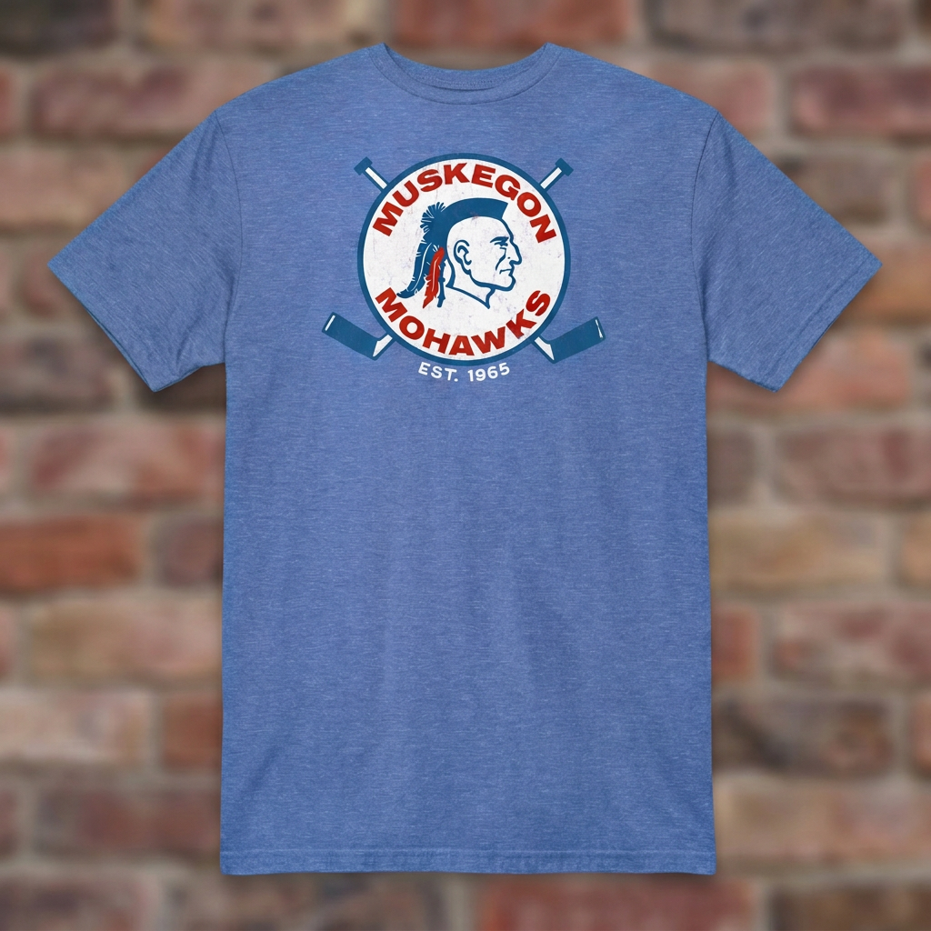 Heather Royal Muskegon Mohawks T-shirt laid flat against a weathered brick background