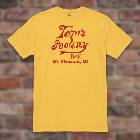 Tom’s Foolery Bar Daisy T-shirt flat lay on brick background