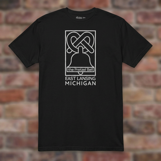 The Pretzel Bell East Lansing Black T-shirt flat lay on brick background