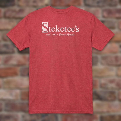 Steketee's Heather Red T-shirt flat lay on brick background