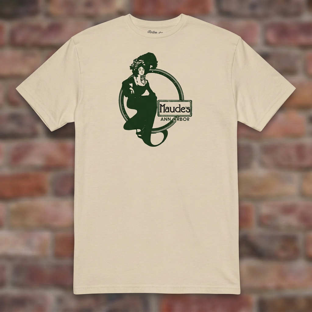 Maude's Sand T-shirt flat lay on brick background