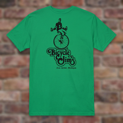 Bicycle Jim's Irish Green T-shirt flat lay on brick background