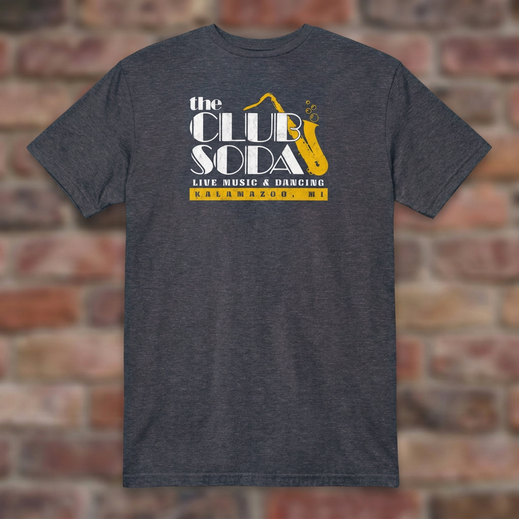 The Club Soda Kalamazoo T-shirt in Heather Navy on a weathered brick background