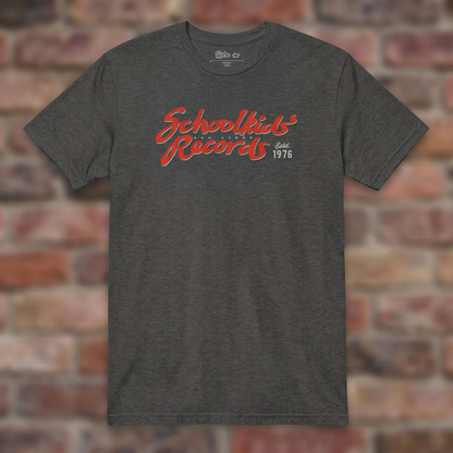 Schoolkids Records Ann Arbor T-shirt in Dark Heather Grey, flat lay on warm brick background