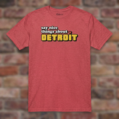 Say Nice Things About Detroit Heather Red T-shirt flat lay on brick background