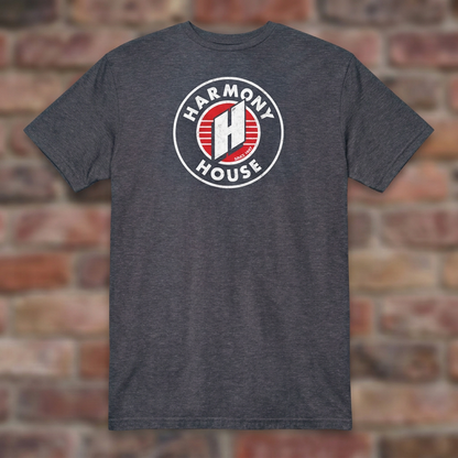 Harmony House Heather Navy T-shirt flat lay on warm brick