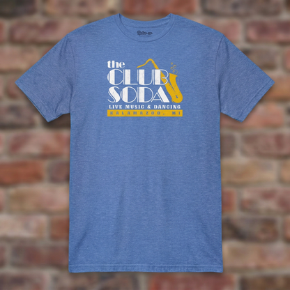 The Club Soda Kalamazoo T-shirt in Heather Royal on a weathered brick background