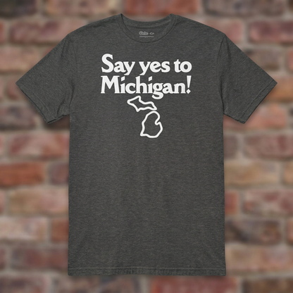 Say yes to Michigan Graphite Heather T-shirt flat lay on brick background